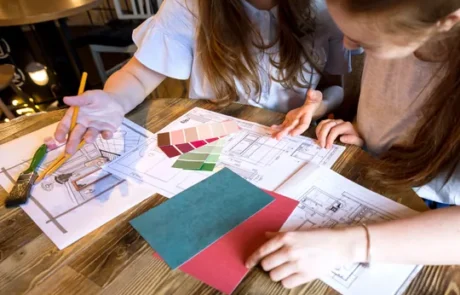 Profesionales del diseño revisando detalles técnicos sobre planos arquitectónicos