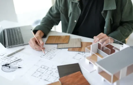 Interioristas planificando proyecto sobre mesa de trabajo con planos y colores
