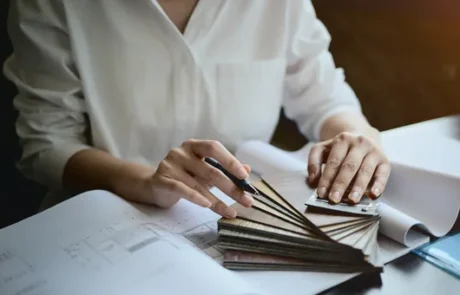 Profesionales revisando planos de interiorismo con herramientas de medición